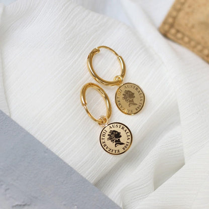 Brinco Feminino Moeda "Câmbio" em Aço Inoxidável – Design Elegante e Significado de Troca Justa – Estilo Minimalista e Moda Contemporânea – Acompanha Bolsa de Veludo